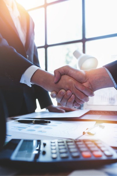 business people shake hands over desk